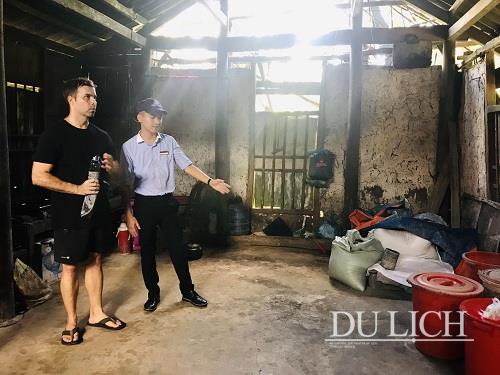 Du khách tham quan bên trong gian nhà tường tranh vách đất của gia đình bà Phạm Thị Hoát và tìm hiểu quy trình nghề nấu rượu truyền thống